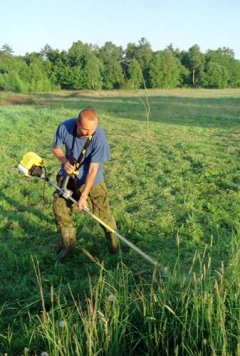 Ochotnik „Salamandry” podczas wykaszania trawy w łowisku dzierzb