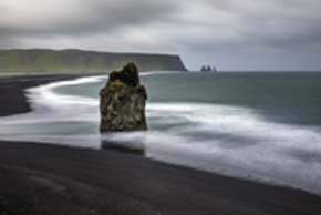 Mniej więcej w połowie drogi między Reykjavíkiem a Jökulsárlón nad brzegiem oceanu leży miejscowość Vík í Mýrdal. Znana jest przede wszystkim ze słynnej czarnej plaży Reynisfjara, zaliczanej do najpiękniejszych plaż świata. Z jednej strony zamknięta niewysoką górą z niezwykłą jaskinią zbudowaną z bazaltowych słupów oraz malowniczymi skałami w wodzie... a z drugiej klifem Dyrhólaey – wymarzonym domem dla wielu gatunków ptaków morskich, m.in. maskonurów